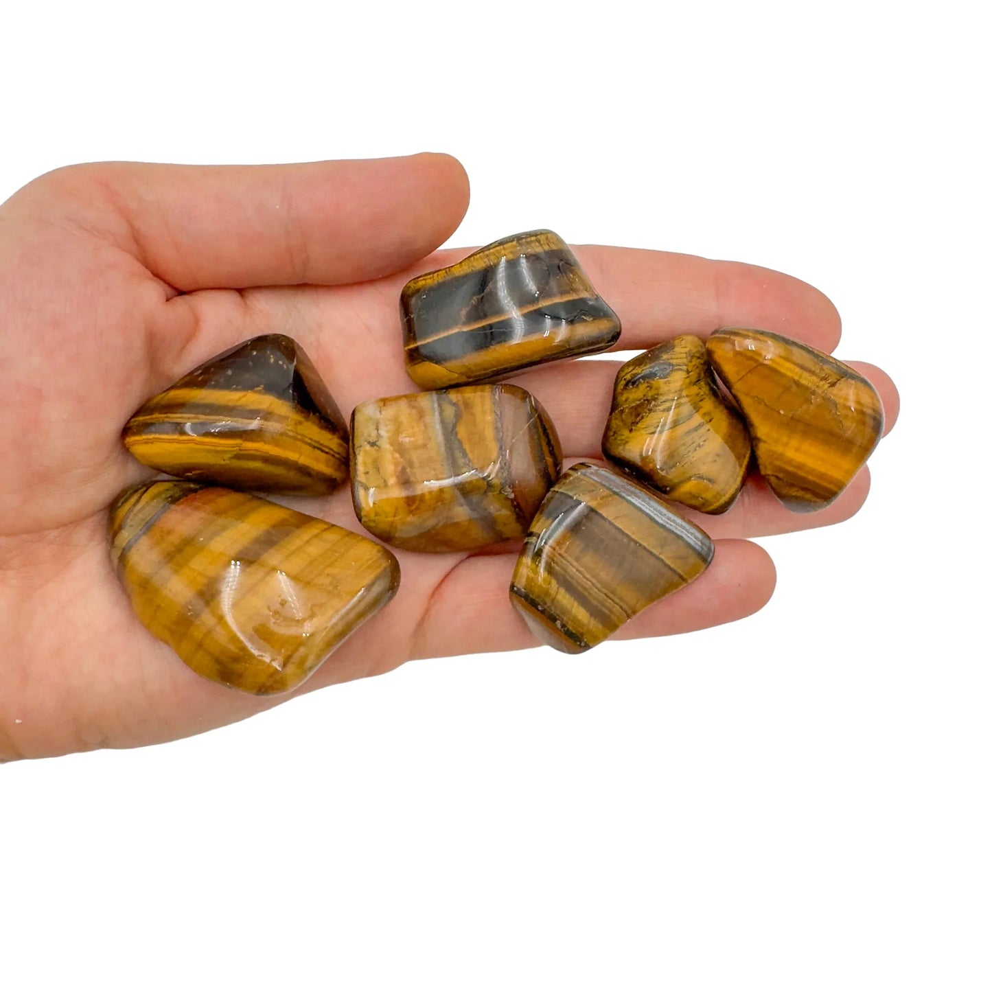Tabletop view of Tiger Eye tumbled stone, from Northern Cape, South Africa, linked to Confidence, captured in natural daylight.