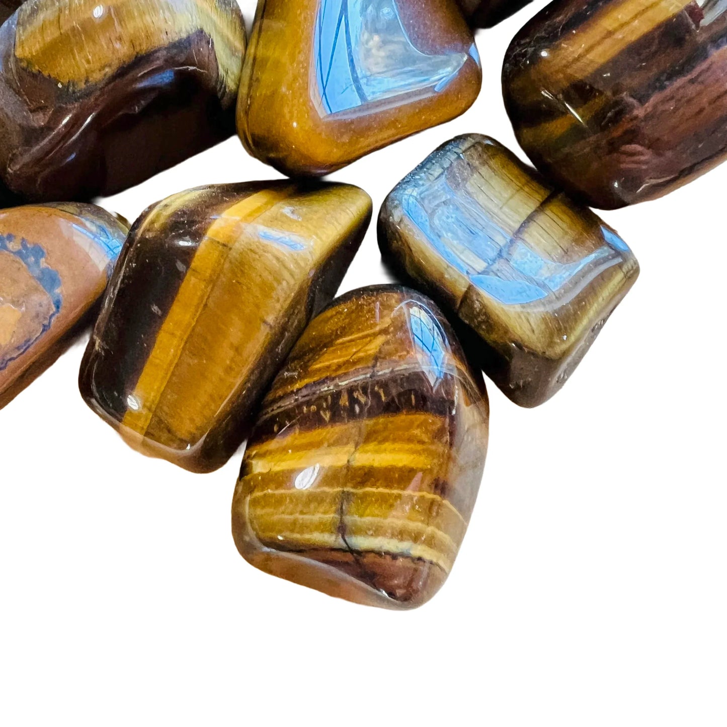Detail shot of Grade A Tiger Eye tumbled stone under natural light