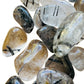 Lifestyle view of one Quartz tumbled stone for scale, from Brazil.