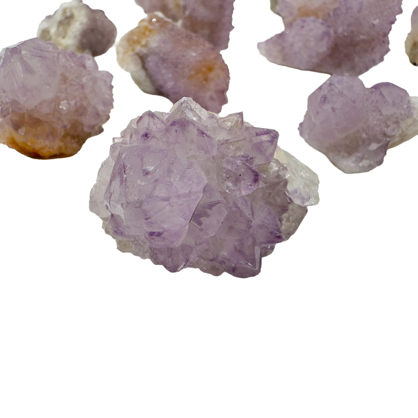 Grouping of Spirit Quartz clusters photographed together, including one broader amethystine specimen alongside smaller single points.