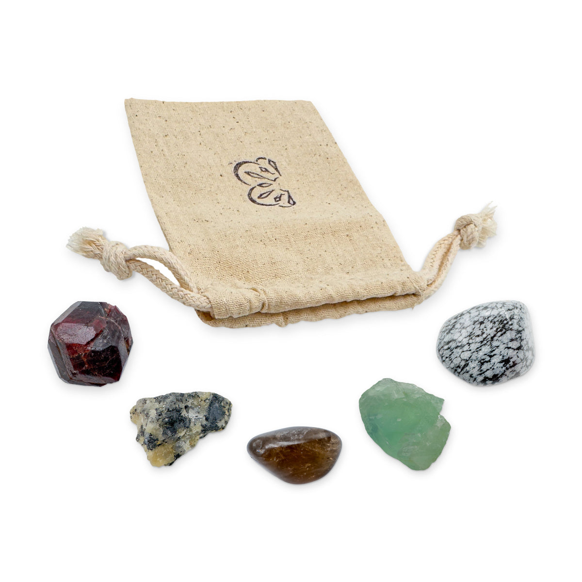 Capricorn Crystal Kit: garnet, black tourmaline in quartz, smoky quartz, fluorite and snowflake obsidian, arranged with the reusable cotton bag they come in, on white