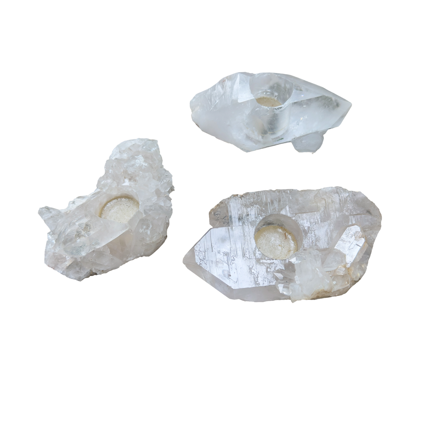 Clear quartz candle holders grouped, showing variation in clarity and crystal point count