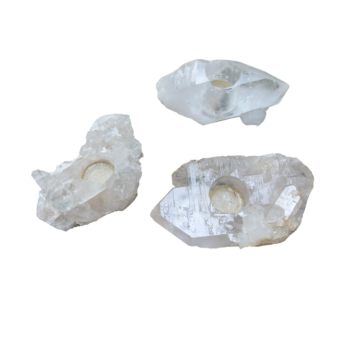 Clear quartz candle holders grouped, showing variation in clarity and crystal point count