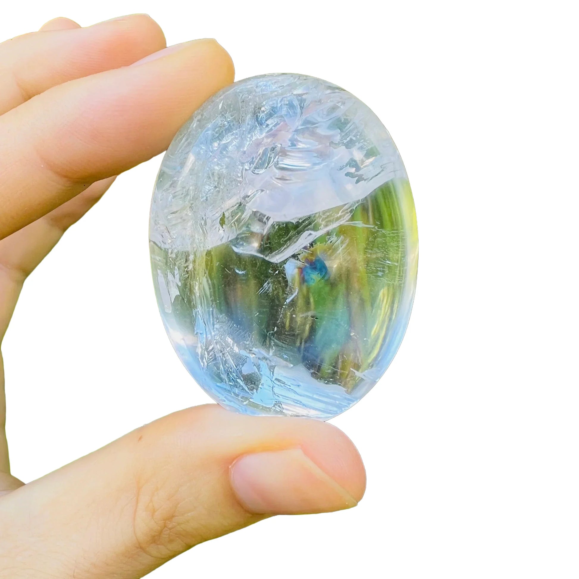 Set against a soft backdrop is a Clear Quartz palm stone, from Vakinankaratra, Madagascar, showing the piece in repose.