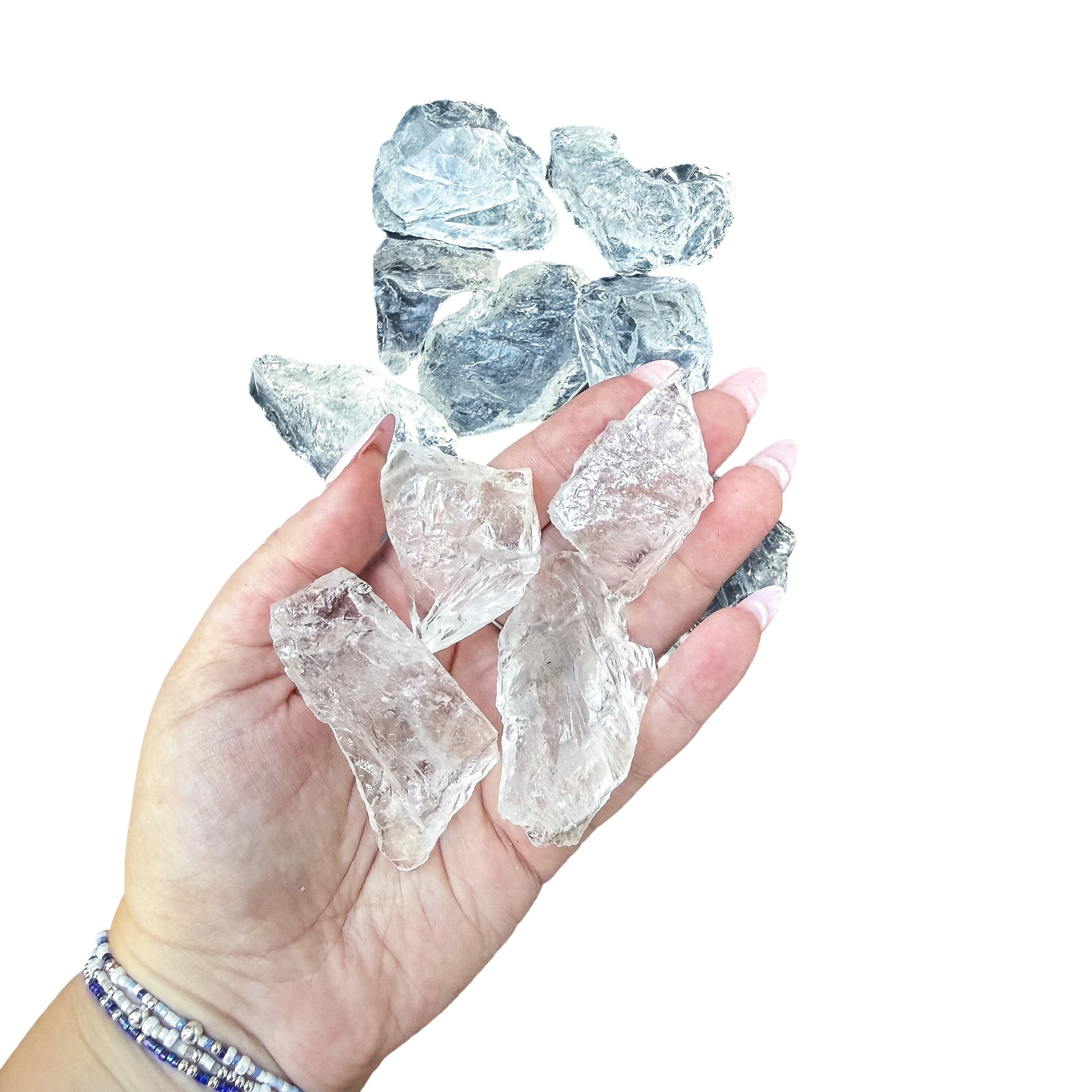 Four Clear Quartz rough pieces held in an open palm, showing the 1 to 2 inch scale