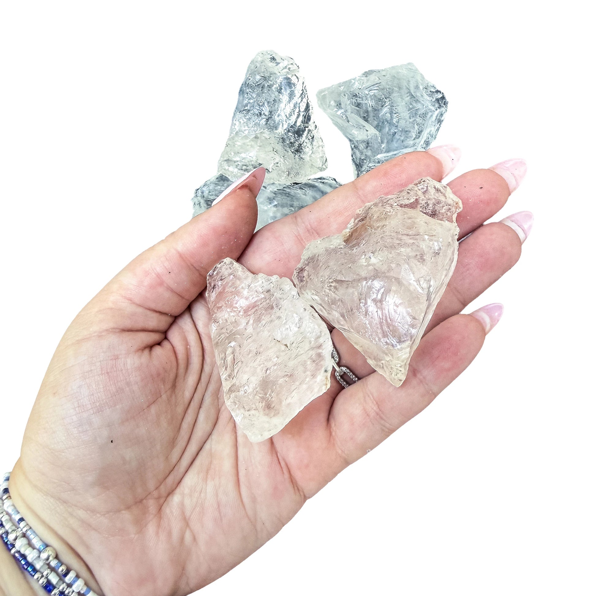Two large Clear Quartz rough pieces filling an open palm, showing the 1.5 to 2.5 inch scale