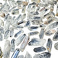 Angled view across a pile of small Clear Quartz points showing the six-sided terminations