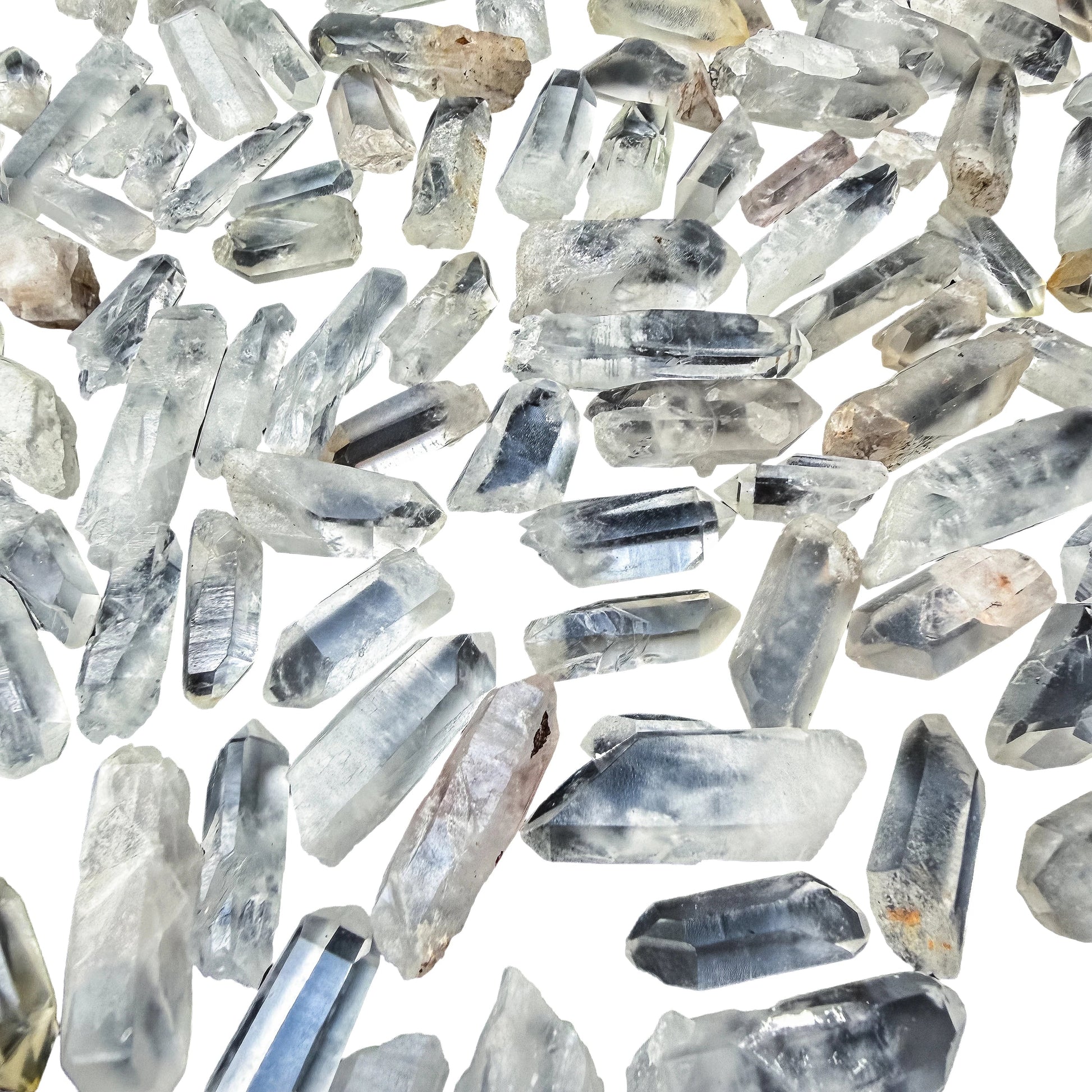 Angled view across a pile of small Clear Quartz points showing the six-sided terminations