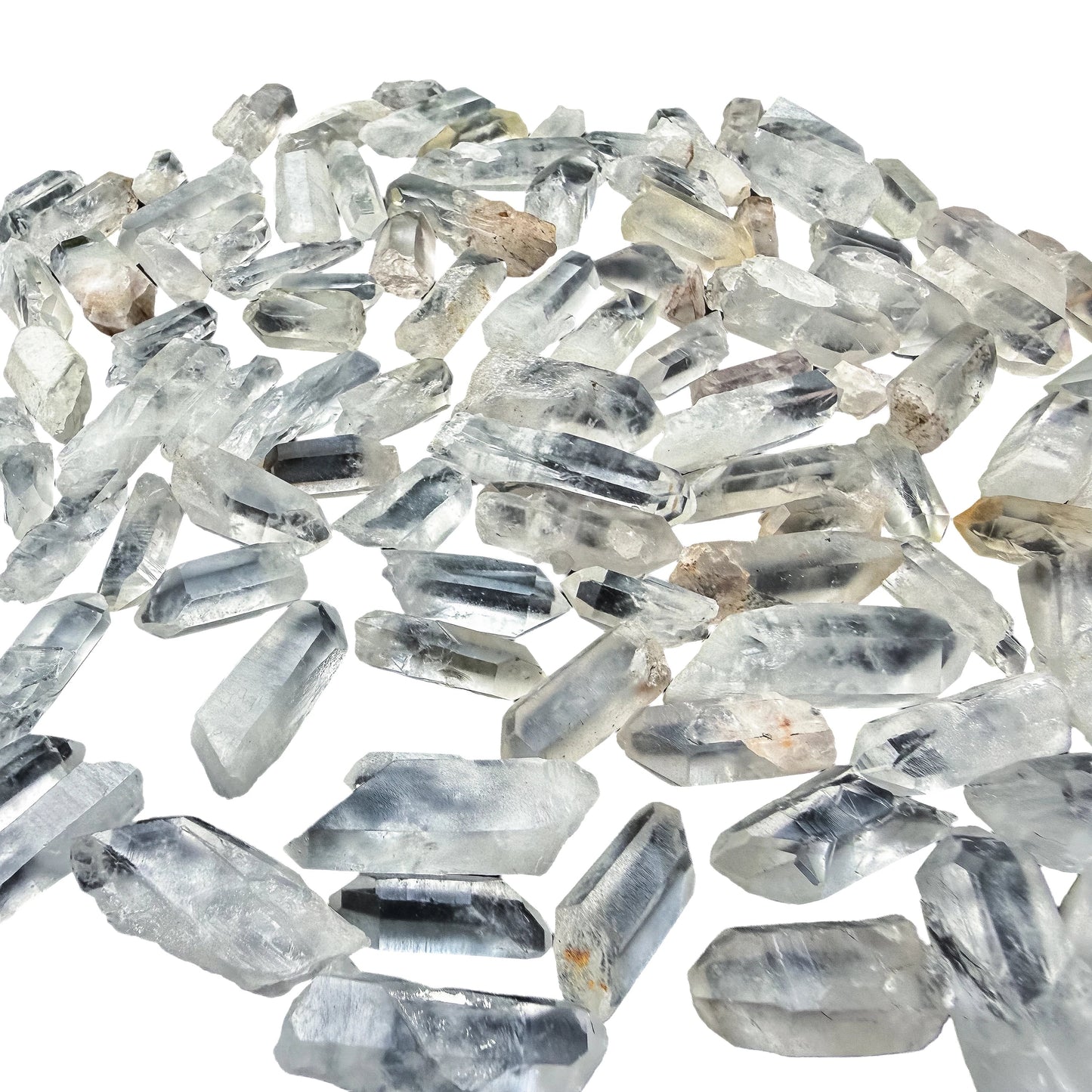 Overhead flat-lay of small Clear Quartz points spread evenly, showing how many come in a pound