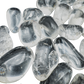 Close-up of polished Clear Quartz tumbled stones showing crystalline depth and natural inclusions, AAA grade Brazil