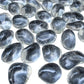Angled view across polished Clear Quartz tumbles showing how much light passes through