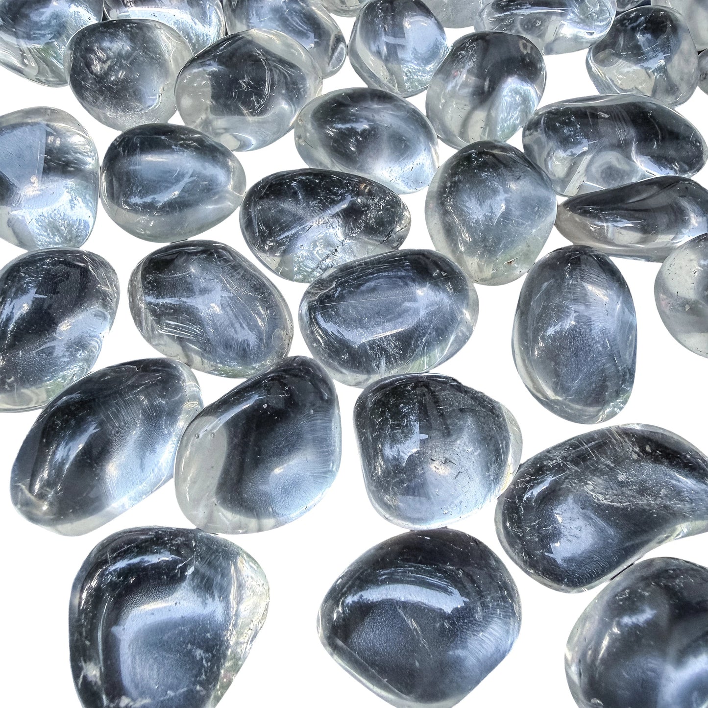 Angled view across polished Clear Quartz tumbles showing how much light passes through