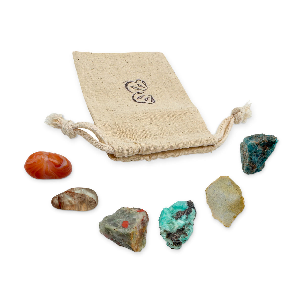 Confidence Crystal Kit: banded carnelian, fire quartz, bloodstone, amazonite, yellow jasper and blue apatite, arranged with the reusable cotton bag they come in, on white