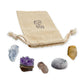 Crown Chakra Crystal Kit: clear quartz, amethyst cluster, lithium quartz point, howlite and rutilated quartz, arranged with the reusable cotton bag they come in, on white