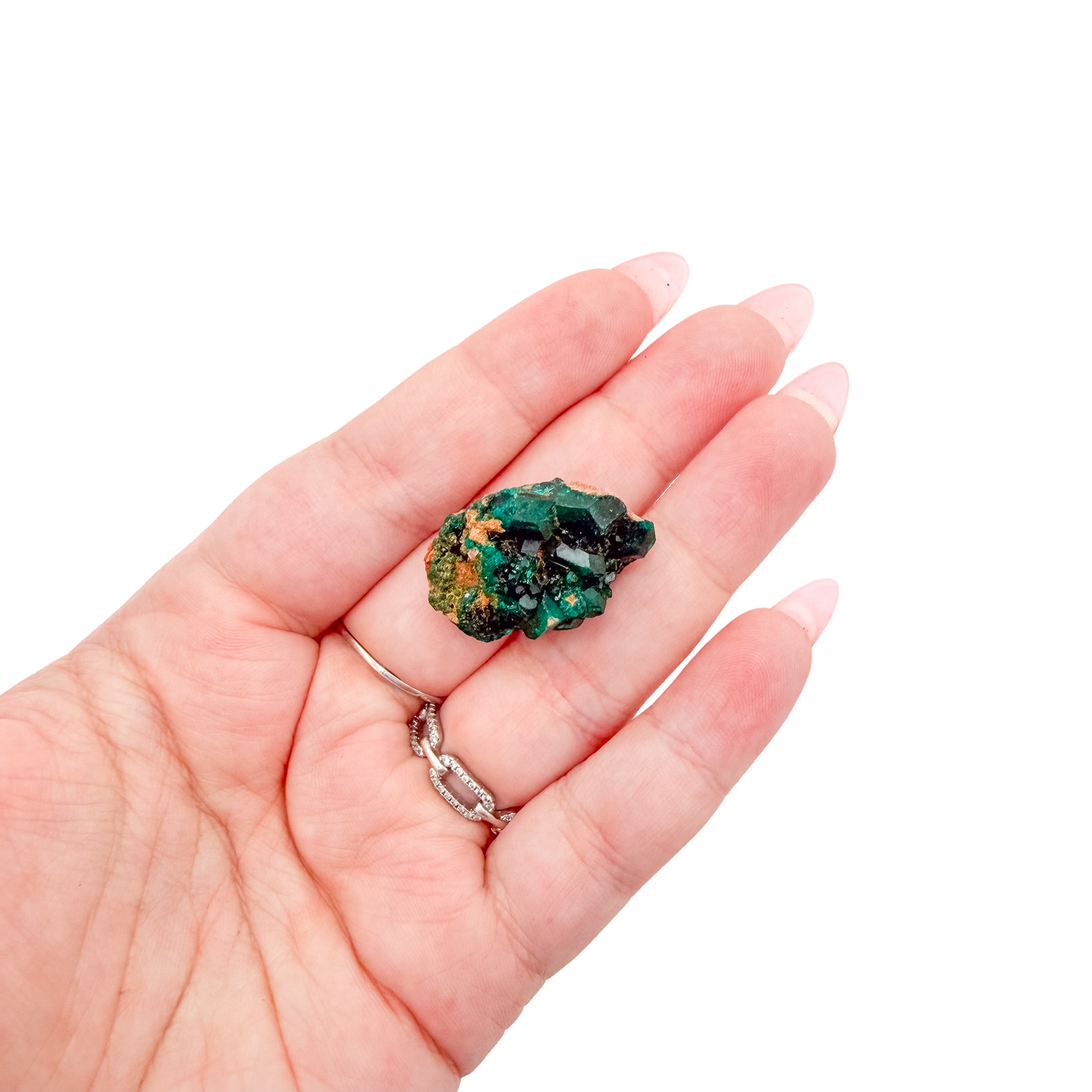 A 15.6 g dioptase, the emerald-green druzy, resting in an open palm for size
