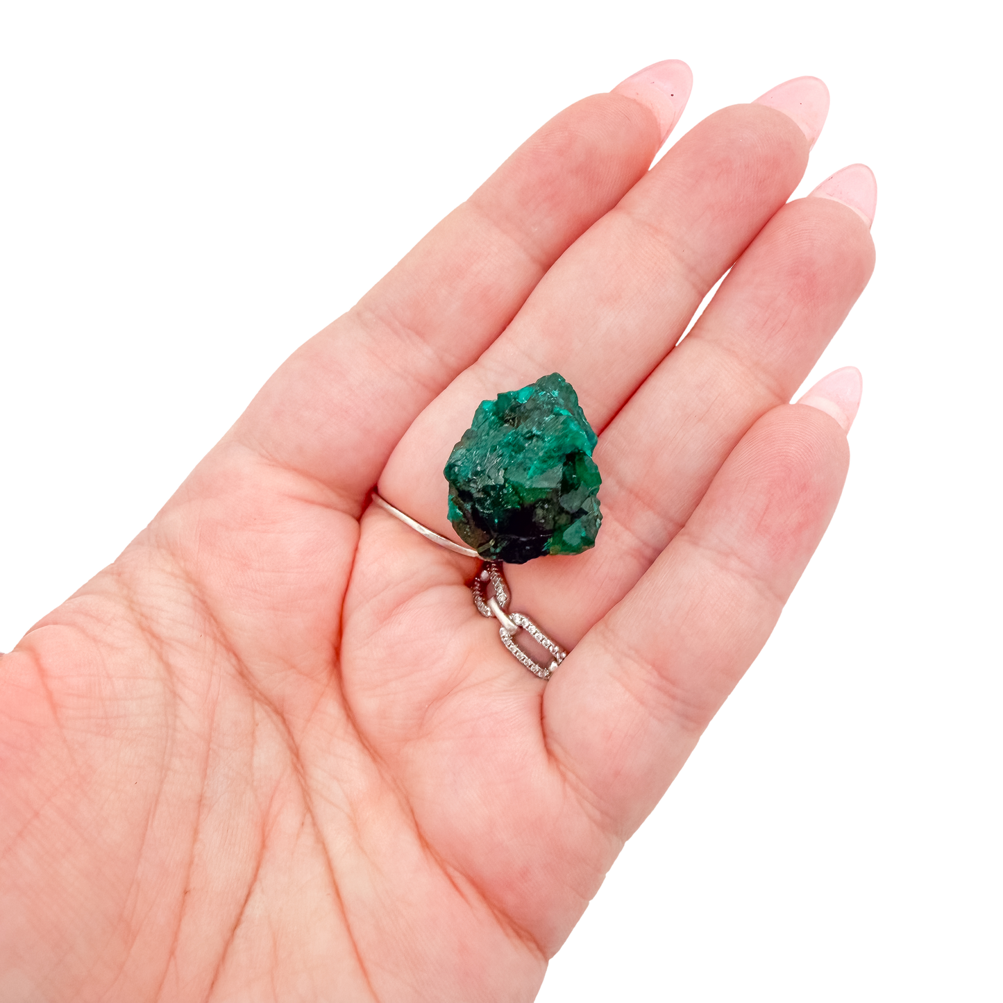Hand holding the bright crystal face to show how small a 1.14 inch collector dioptase is