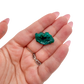 A 13.3 g dioptase, the wide flat plate, resting in an open palm for size