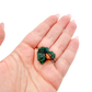Hand holding the cabinet-grade piece to show how small a 1.57 inch collector dioptase is