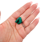 A 21.3 g dioptase, the largest of the lot, resting in an open palm for size