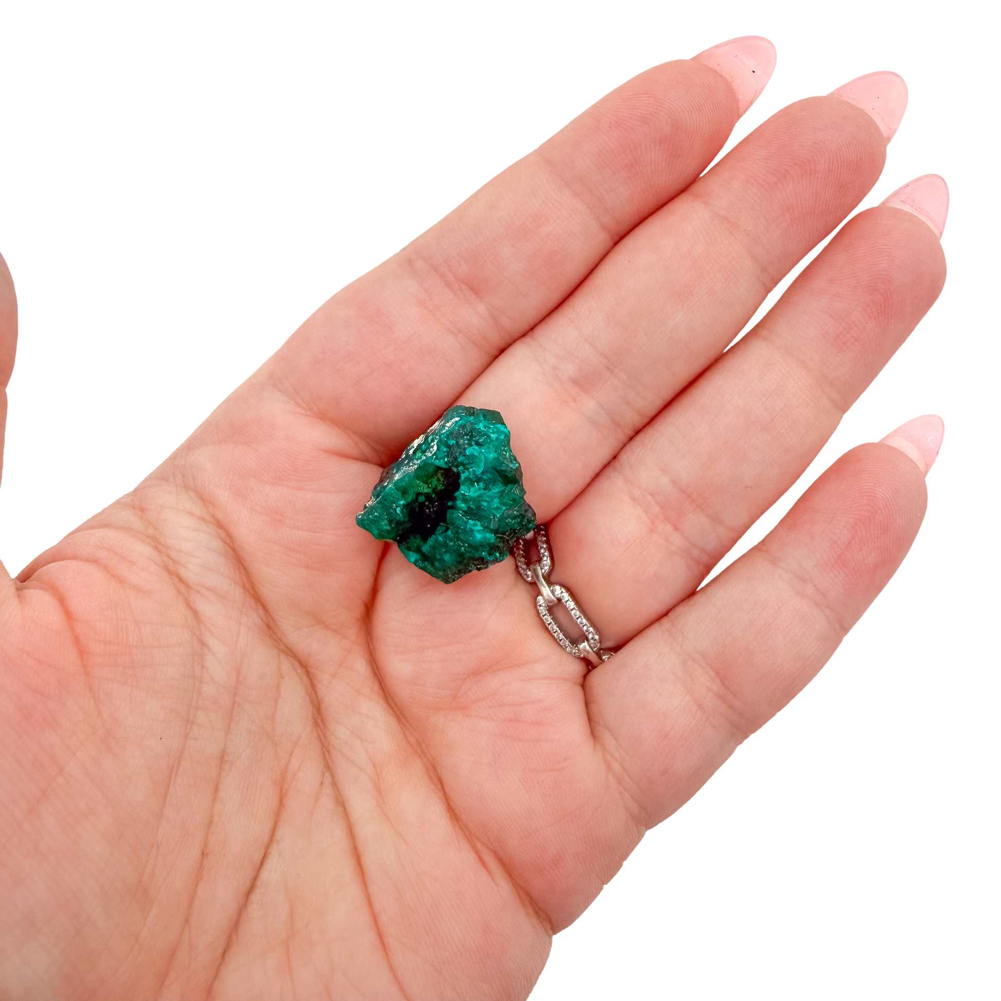 A 21.3 g dioptase, the largest of the lot, resting in an open palm for size