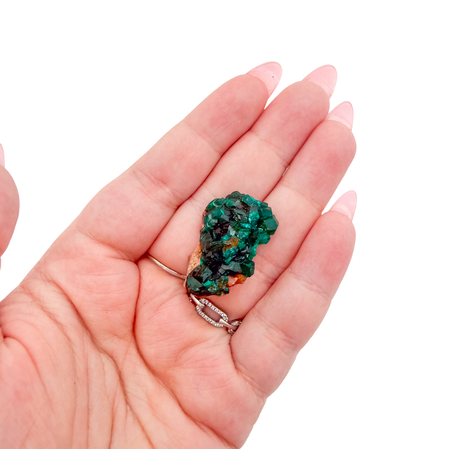 The compact sparkle held in a hand, showing the true scale of this 1.13 inch dioptase