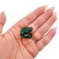 Hand holding the tall little block to show how small a 0.95 inch collector dioptase is