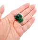 A 8.3 g dioptase, the cubic thumbnail, resting in an open palm for size