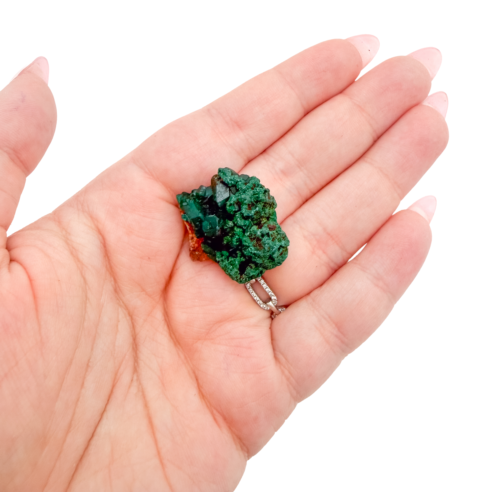 A 8.3 g dioptase, the cubic thumbnail, resting in an open palm for size