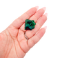 A 8.6 g dioptase, the narrow green blade, resting in an open palm for size