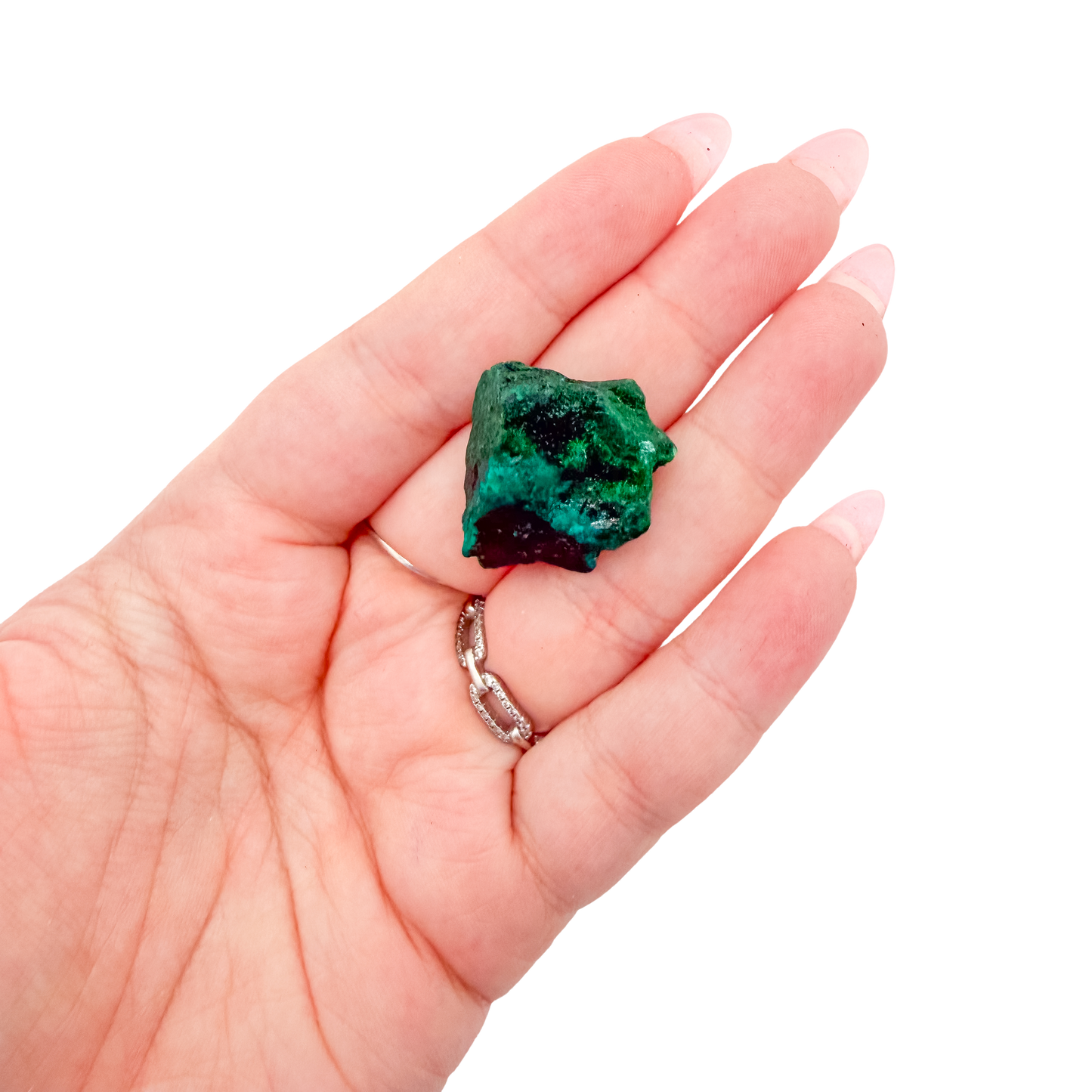 A 8.6 g dioptase, the narrow green blade, resting in an open palm for size