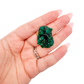 A 5.6 g dioptase, the delicate sliver, resting in an open palm for size