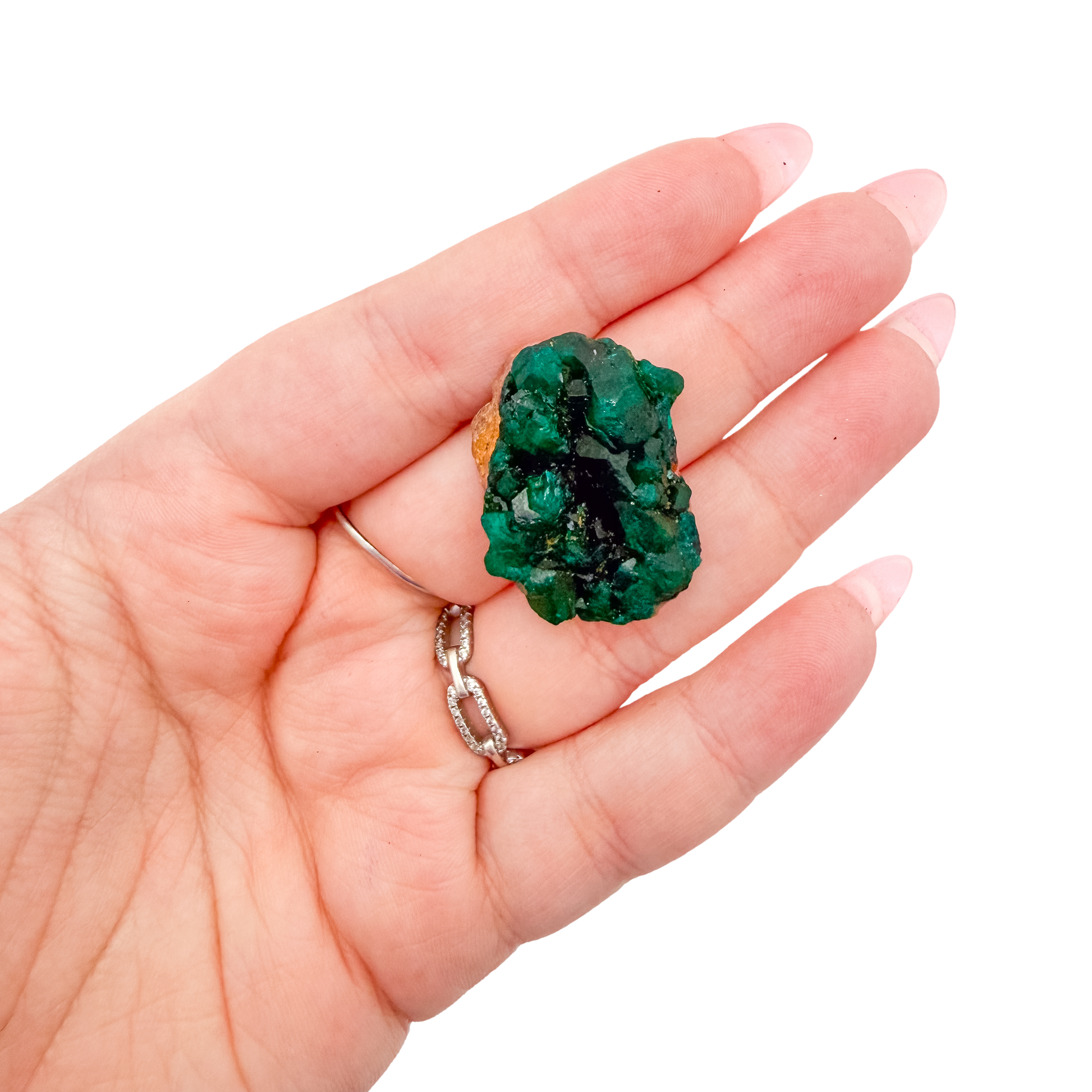 A 5.6 g dioptase, the delicate sliver, resting in an open palm for size