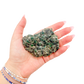 Raw emerald specimen from Zimbabwe held in hand to show scale