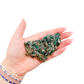 Raw emerald specimen from Zimbabwe held in hand to show scale