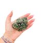 Raw emerald specimen from Zimbabwe held in hand to show scale