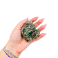 Raw emerald specimen from Zimbabwe held in hand to show scale