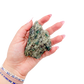 Raw emerald specimen from Zimbabwe held in hand to show scale