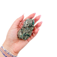 Raw emerald specimen from Zimbabwe held in hand to show scale