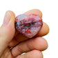 Side profile of Fire Quartz polished heart, sourced from Madagascar, showing color depth.