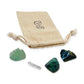 Focus Crystal Kit: fluorite, clear quartz point, azurite and black onyx, arranged with the reusable cotton bag they come in, on white