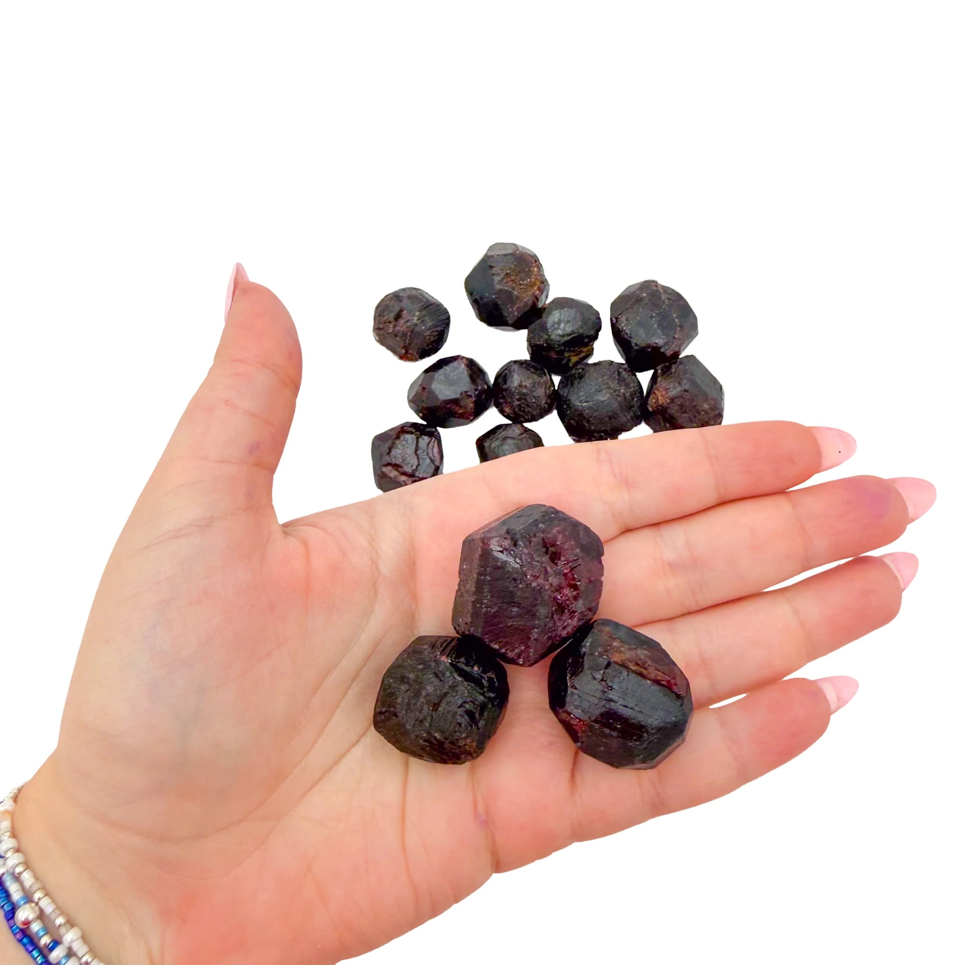 Raw Garnet crystals held in an open palm for scale, 0.75 to 1.50 inch range