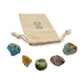 Gemini Crystal Kit: blue apatite, natural citrine, serpentine, crazy lace agate and blue onyx, arranged with the reusable cotton bag they come in, on white