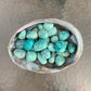 Detail shot of Grade A Chrysocolla tumbled stone under natural light