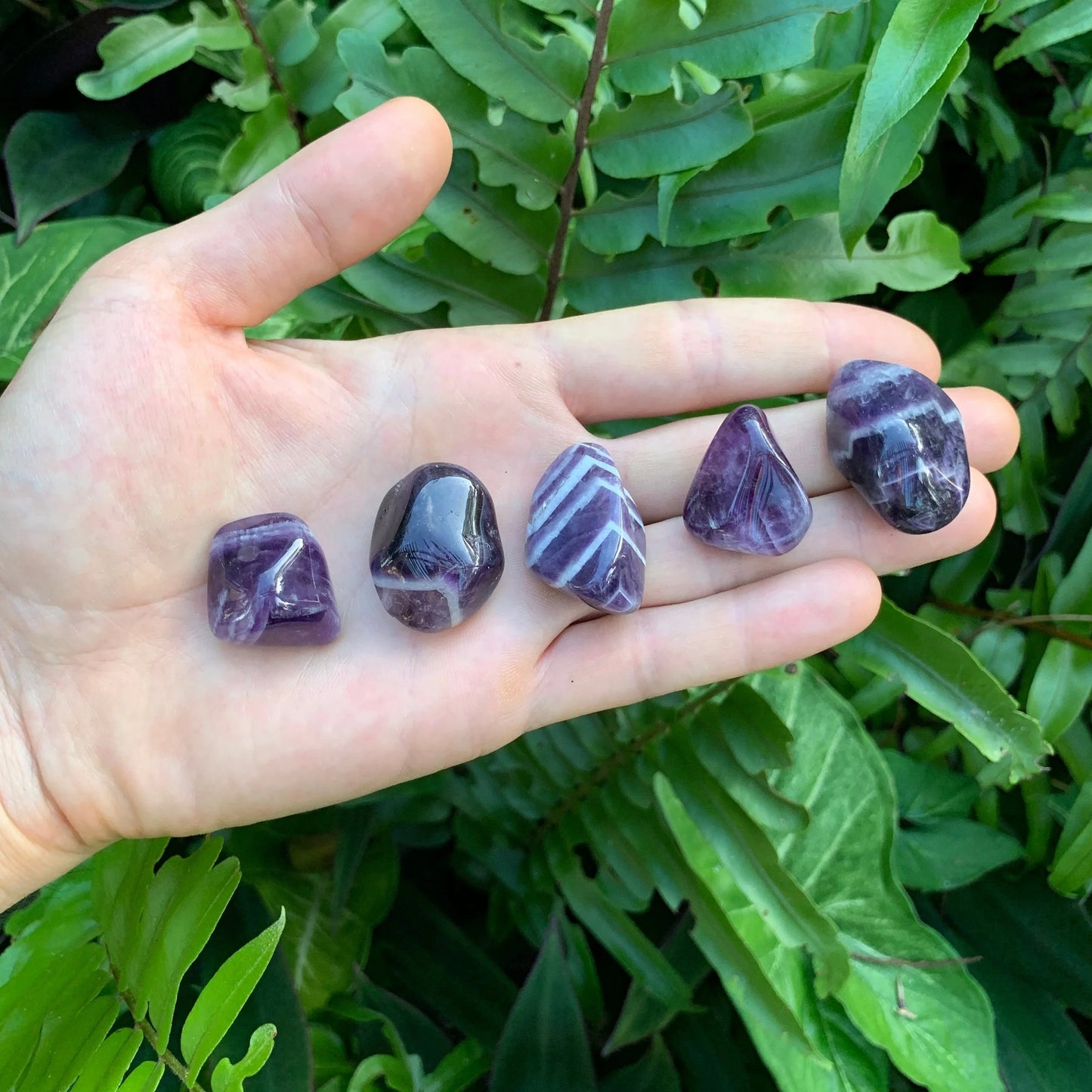Palm-scale view of a Chevron Amethyst tumbled stone, Zambia-sourced, sourced from Zambia.