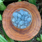 Full piece view of Celestite tumbled stone, from Sakoany, Madagascar, with weight visible in the palm.