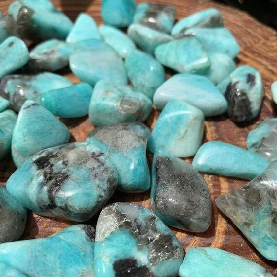 Grade aa amazonite tumbled stone held in hand for size reference