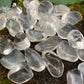 Composed shot of Clear Quartz tumbled stone, linked to Manifestation, with surface texture in view.