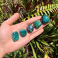Detail shot of Grade AA Chrysocolla tumbled stone under natural light
