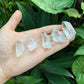 Holding a Clear Quartz raw crystal, from Minas Gerais, Brazil, with form visible in context.
