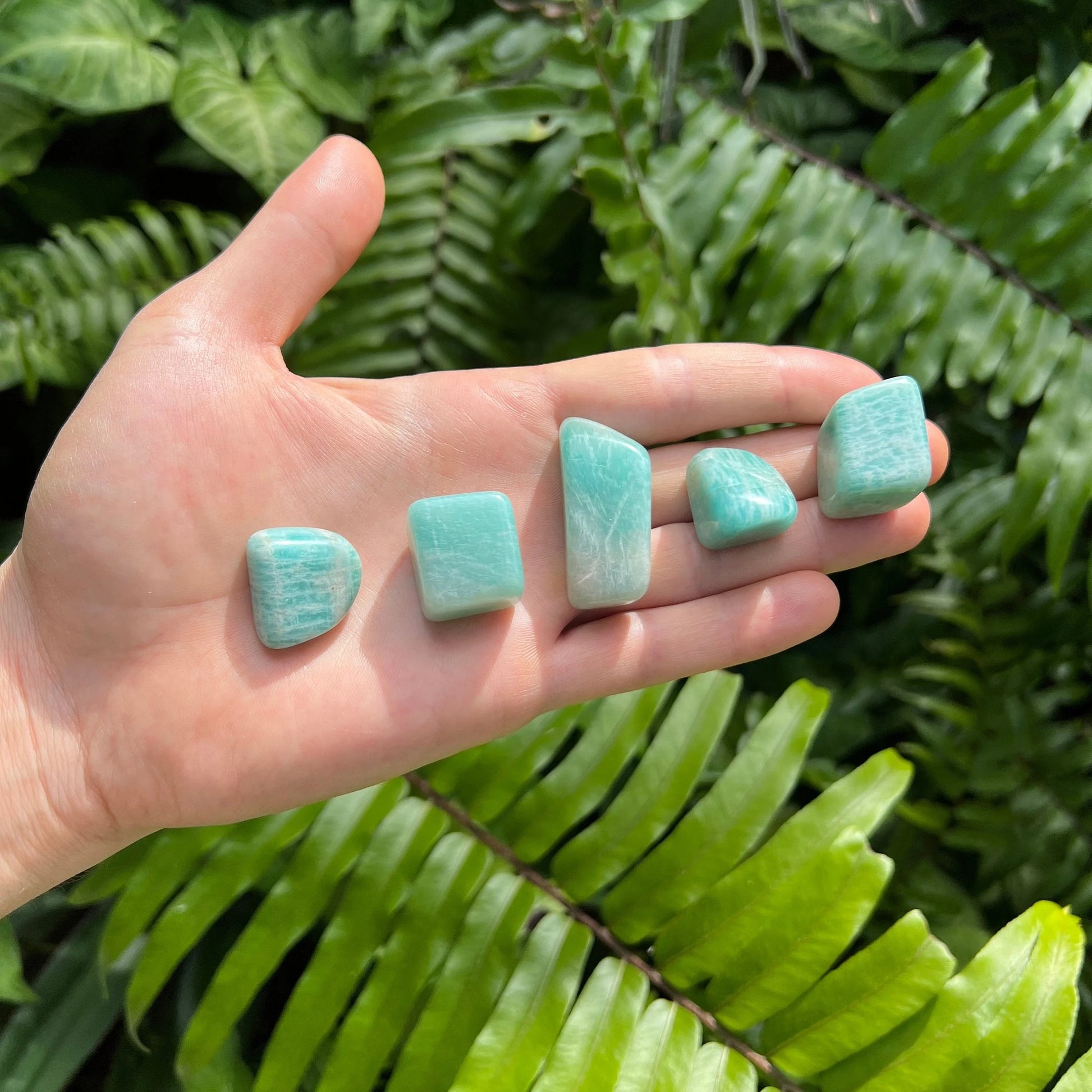 In-hand view of one Amazonite tumbled stone for scale, from Mozambique.